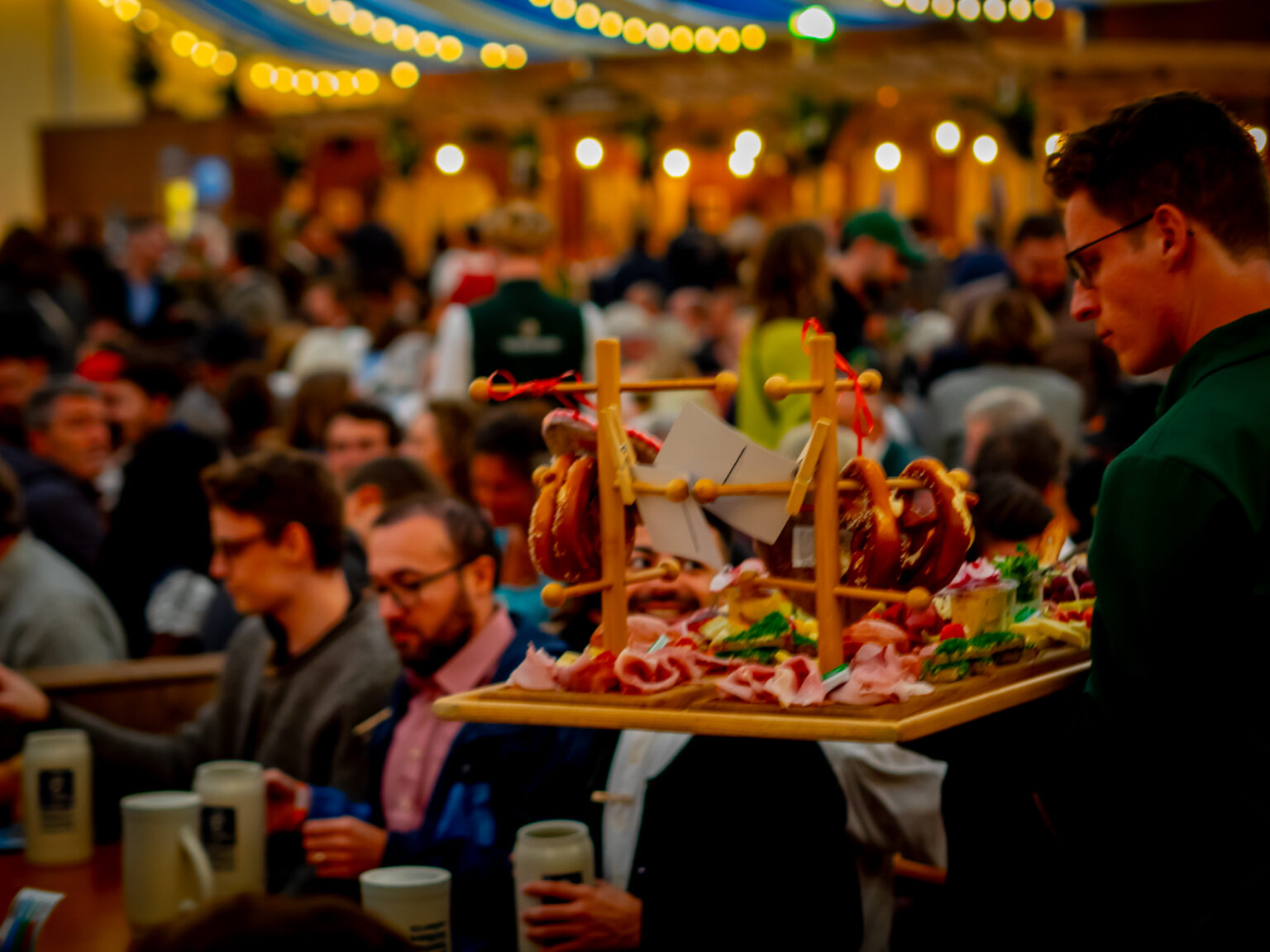 Das Musikantenzelt Boandlkramerei® auf der Oidn Wiesn – Servicekraft mit Brotzeitbrettl